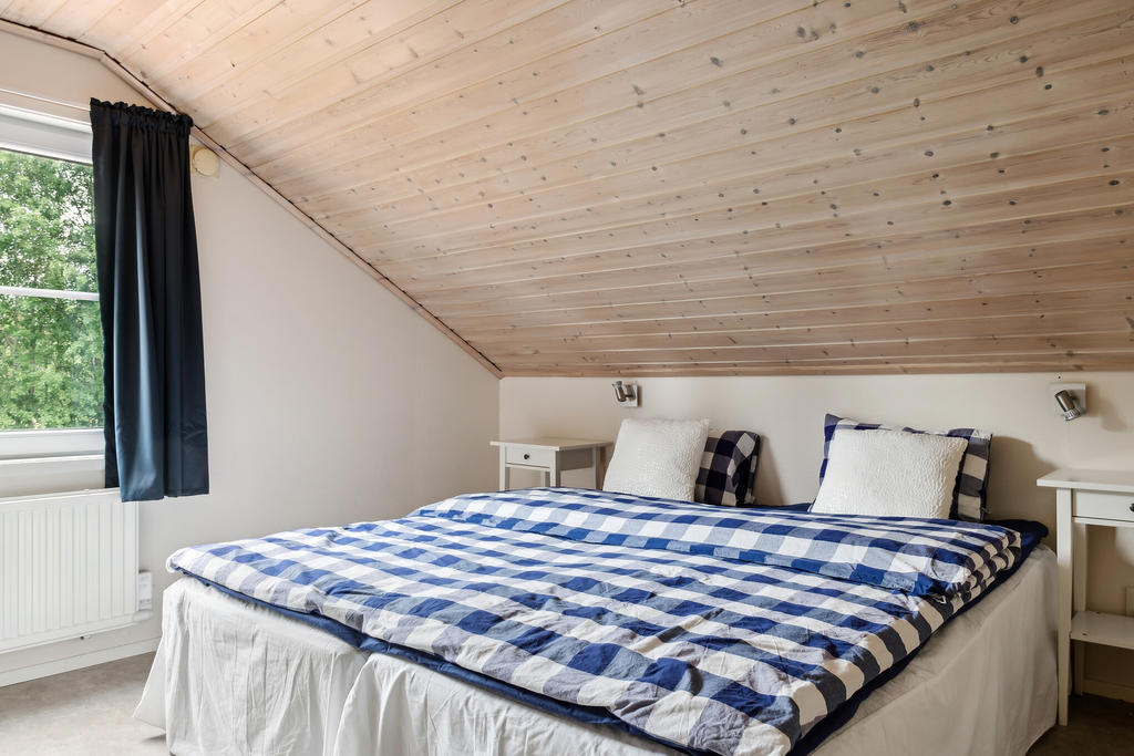 Master bedroom på övervåningen erbjuder fantastiskt ljusinsläpp och gott om plats för en stor dubbelsäng. Med sitt mysiga och välkomnande intryck blir detta rummet där du kan koppla av och njuta av en god natts sömn.