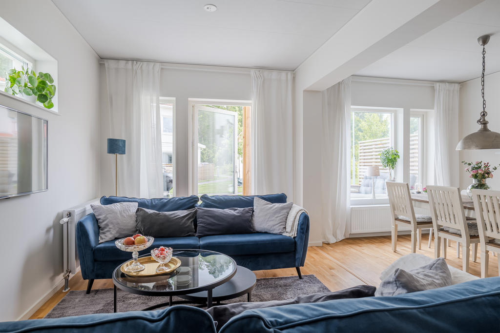 Social yta i vardagsrummet/allrummet med plats för soffor och utgång till altan