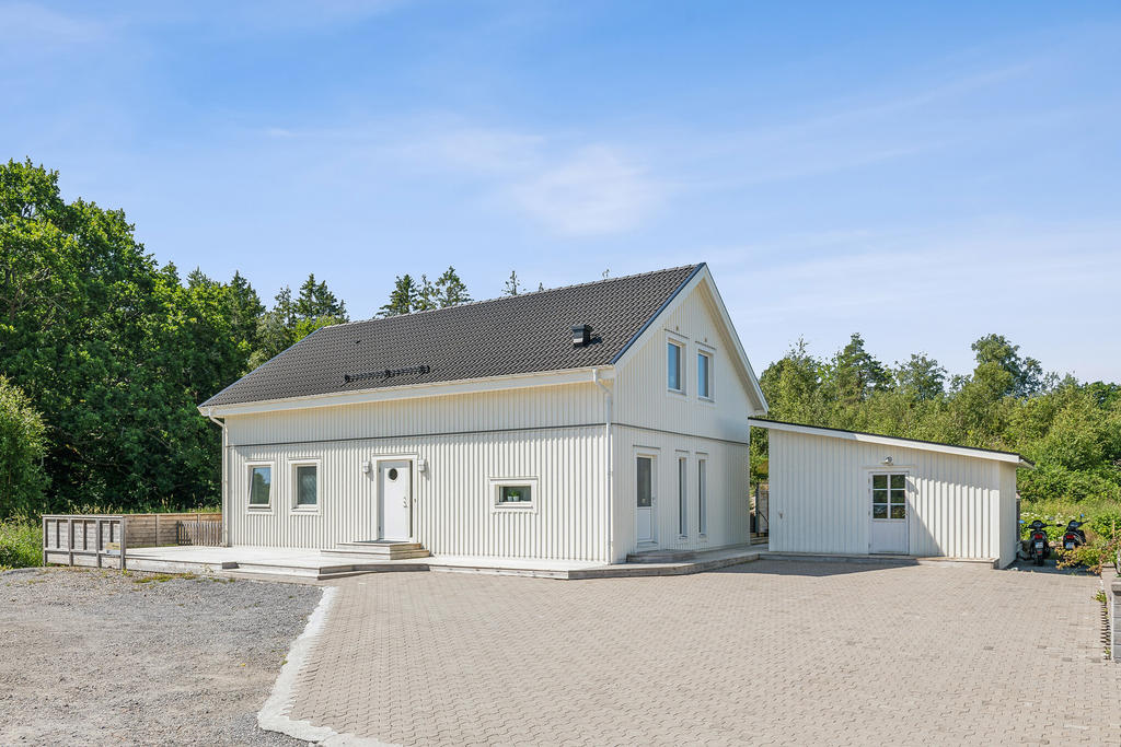 Entrésidan huset med plats för 6 stycken bilar på uppfarten. Morgonsol i öster finner vi på denna sida av huset.