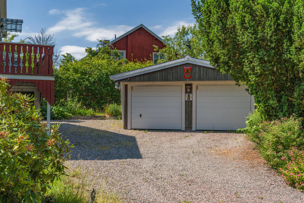 Dubbelgarage och uppställningsplats för fler bilar. Entré till ena lägenheten på gaveln ses i bild
