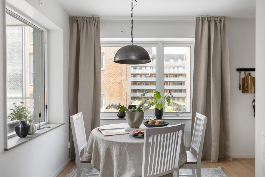 Köket och matplatsen badar i ljus tackar vare de stora fönstren i vinkel