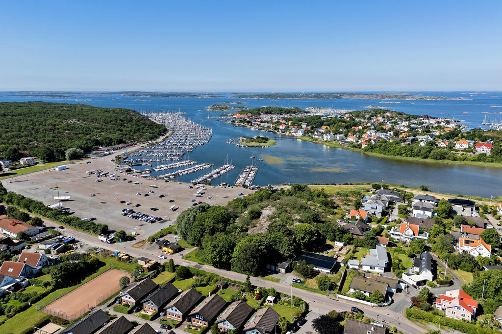 Huset ligger längst in på återvändsgata, intill lekpark med bollplan. Hinsholmskilens båthamn ligger på andra sidan gatan.
