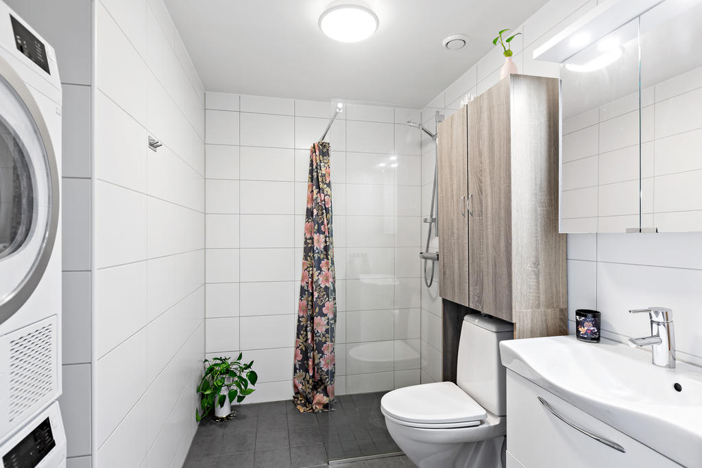 Stort helkaklat badrum med tvättpelare