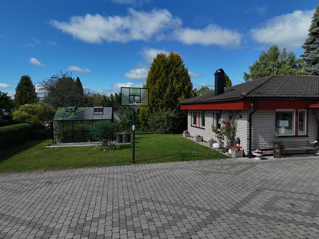 Framför huset står ett växthus