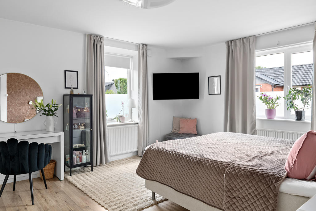 Stort sovrum på entréplan med hel garderobsvägg och mycket ljus. 