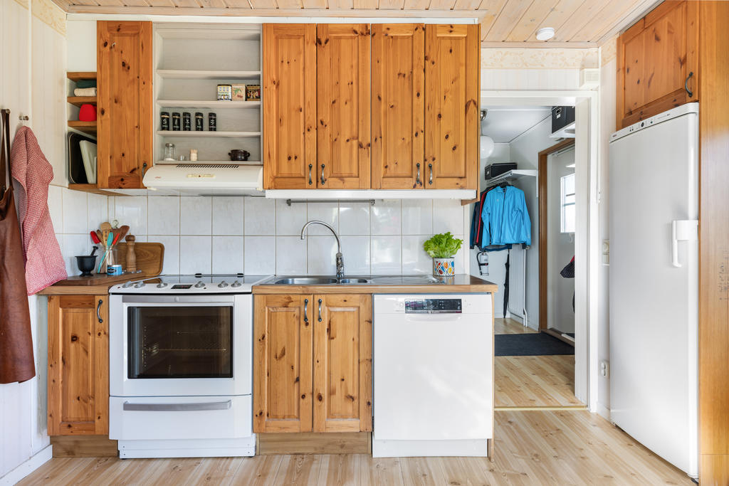 Kök med spis, fläkt, diskmaskin, kyl och frys