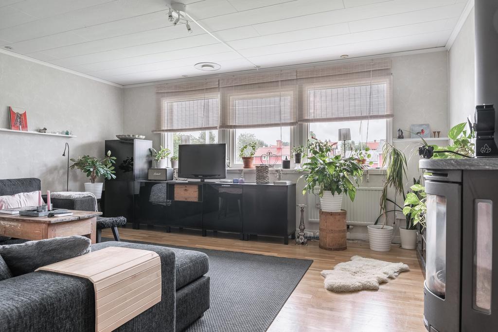 Ljust och rymligt vardagsrum med stora fönster som släpper in härligt dagsljus.