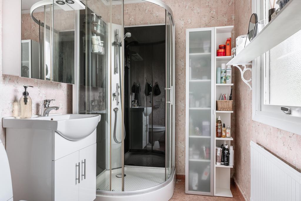 Badrum med duschkabin, handfatskommod och bra förvaringslösningar.