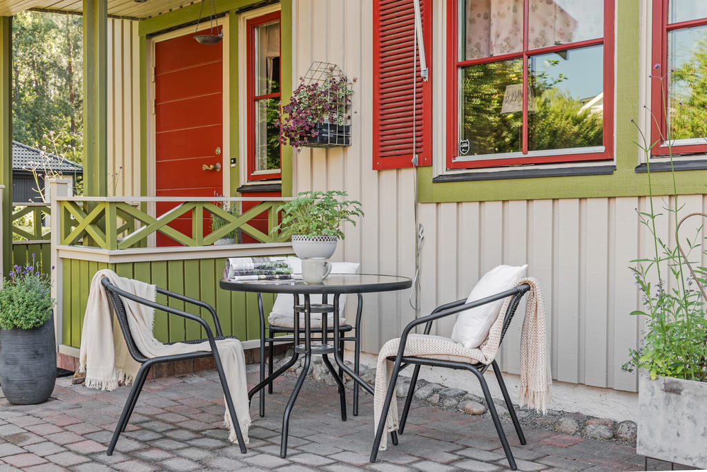 Plattsatt uteplats på framsidan av huset samt fin veranda till huvudentrén.