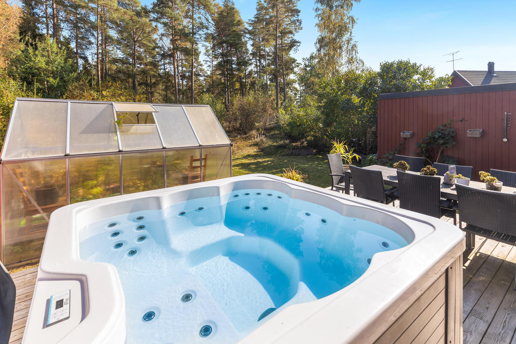 Baksida med jacuzzi och växthus