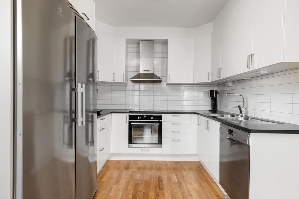 Ljust kök, väl utrustat med vitvaror från Electrolux och förvaring.