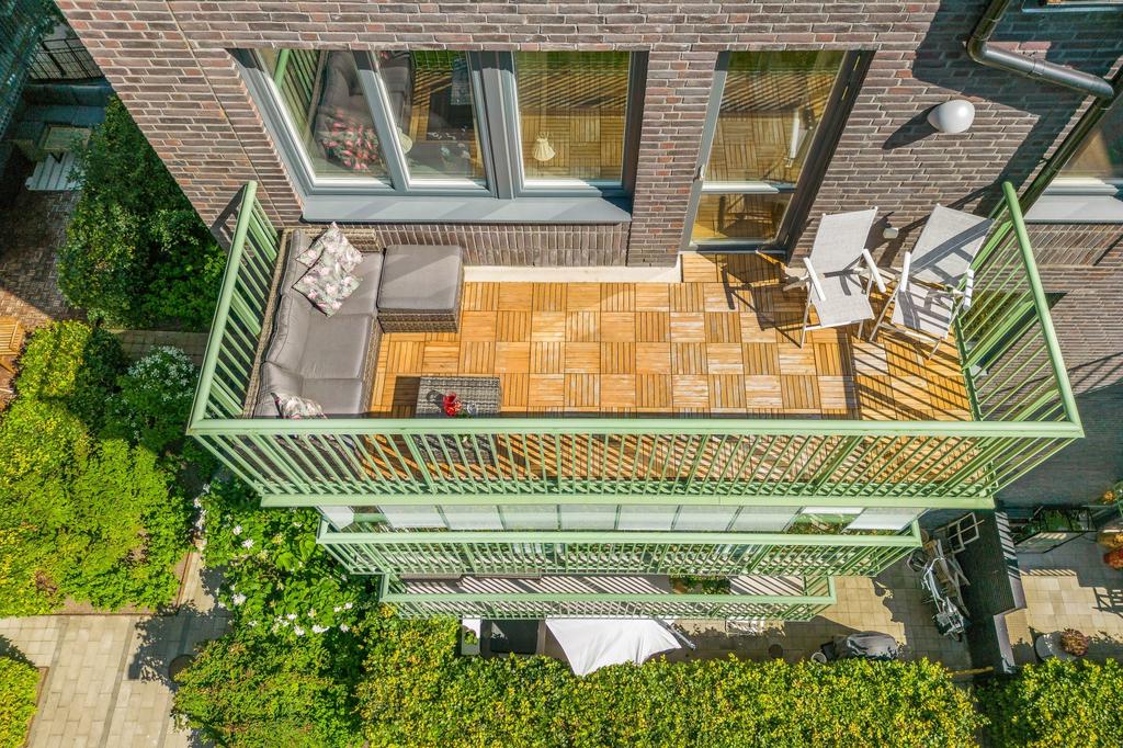 Gott om plats för loungemöbler och solstolar på trädäckad balkong om 11 m²