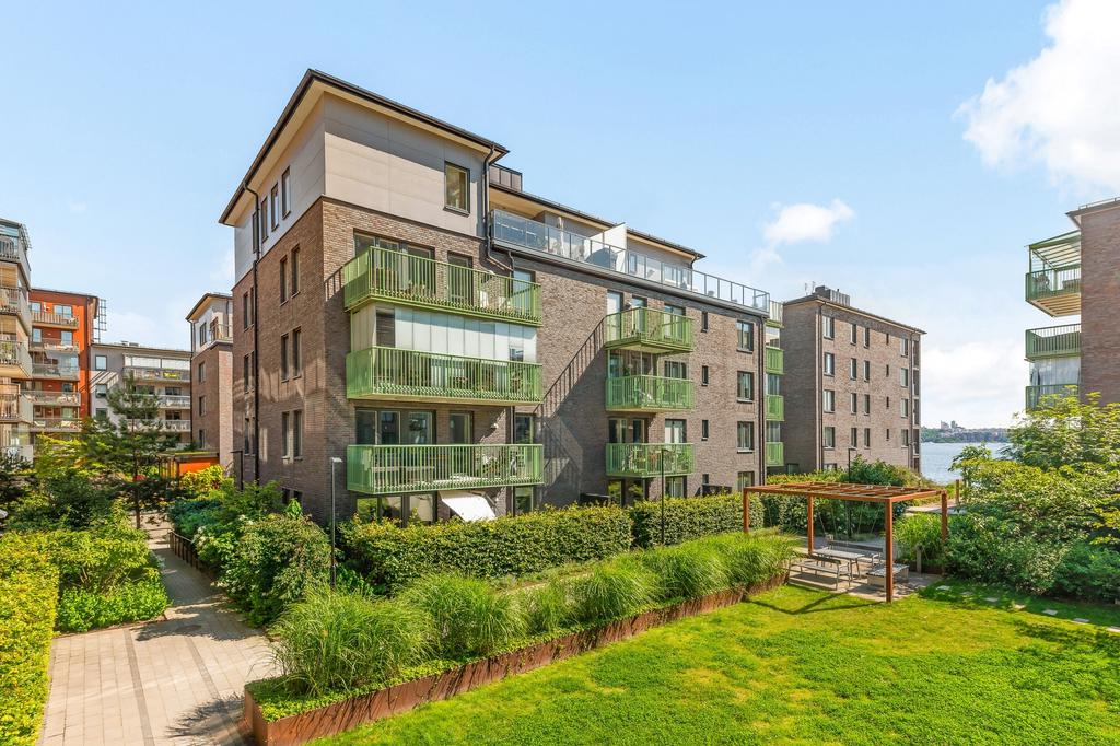 Föreningens grönskande trädgård med Pergola, sittgrupp, lekhörna för barnen och plana sociala gräsytor