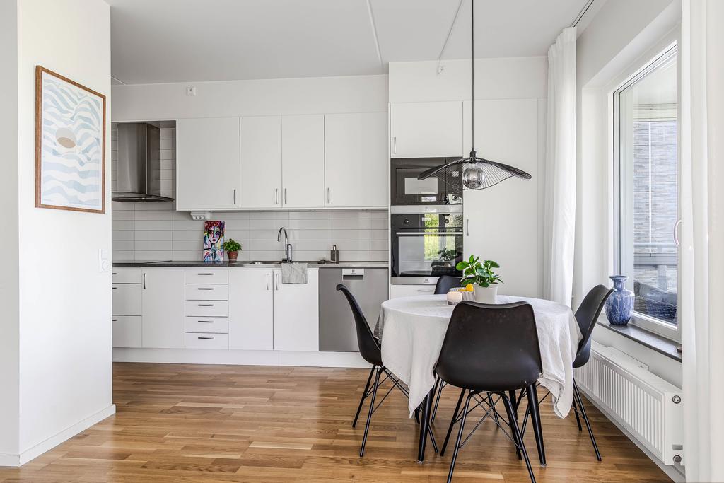 Köket som ligger halvt öppet mot vardagsrummet ä både inbjudande och praktiskt 