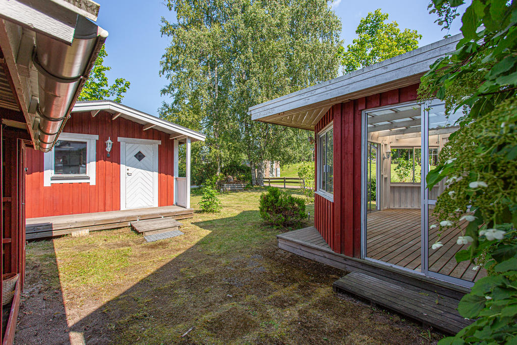 Baksida med friggebod och förrådsbyggnad