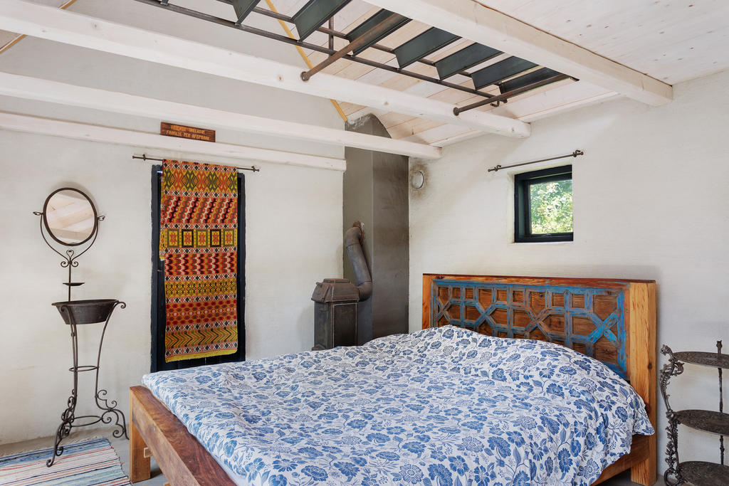 Gästrum i ena uthuset. Fungerande kamin och sovlovft som man når genom att fälla ner stegen 