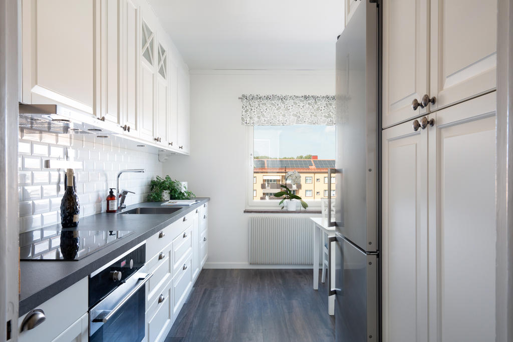 Nyare köksinredning i lantlig stil med integrerade vitvaror