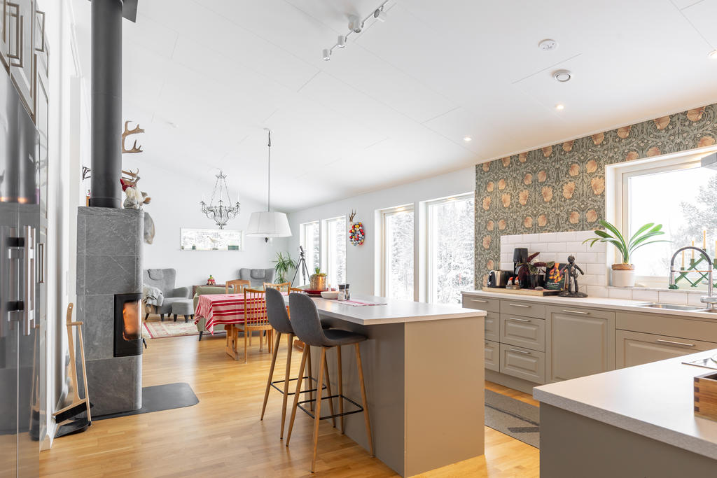 Ljust vardags rum med stora fönster med utsikt över fjällen.