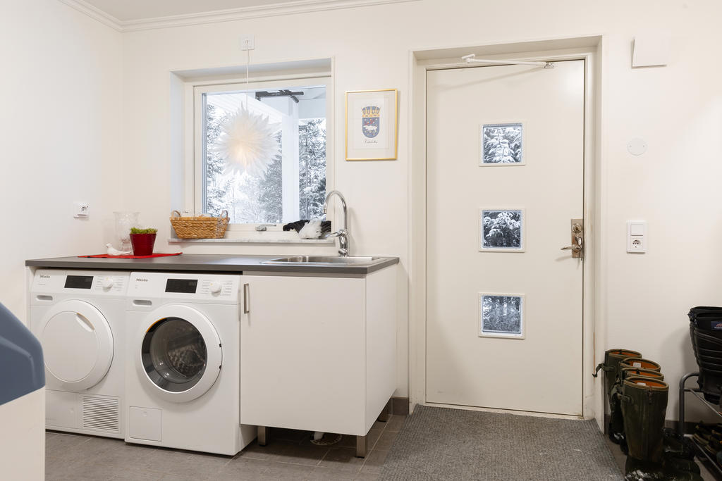 Husets andra hall med tvättstuga med Miele vitvaror.