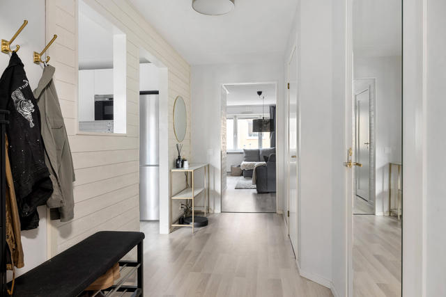 Hall med öppning in mot köket som släpper in dagsljuset
