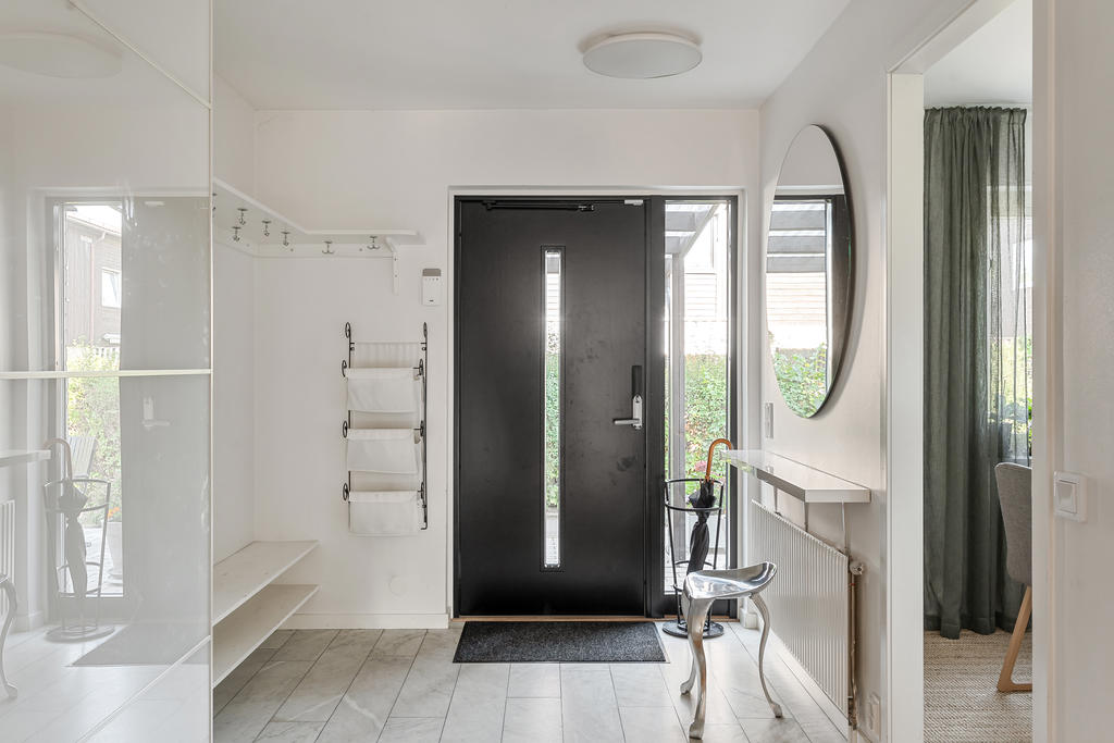 Hall med klinkergolv och plats för avhängning och skjutgarderober.