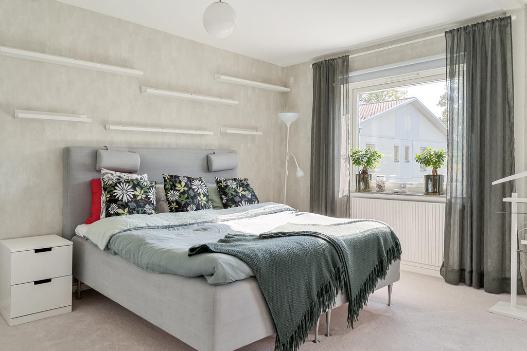 Sovrum (1) på övre plan med heltäckande matta och plats för stor säng.