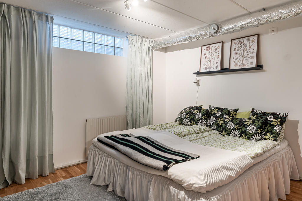 Sovrum (4) i källarplan med plats för stor säng och enkelt möblemang.