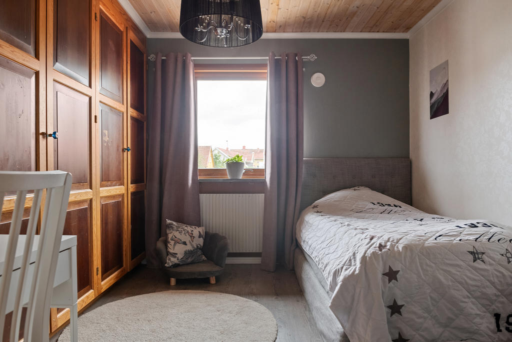 Stort och ljust sovrum på övre plan med plats för enkelsäng och garderober. Här kan du njuta av det härliga ljusinsläppet och utrymmen för förvaring.