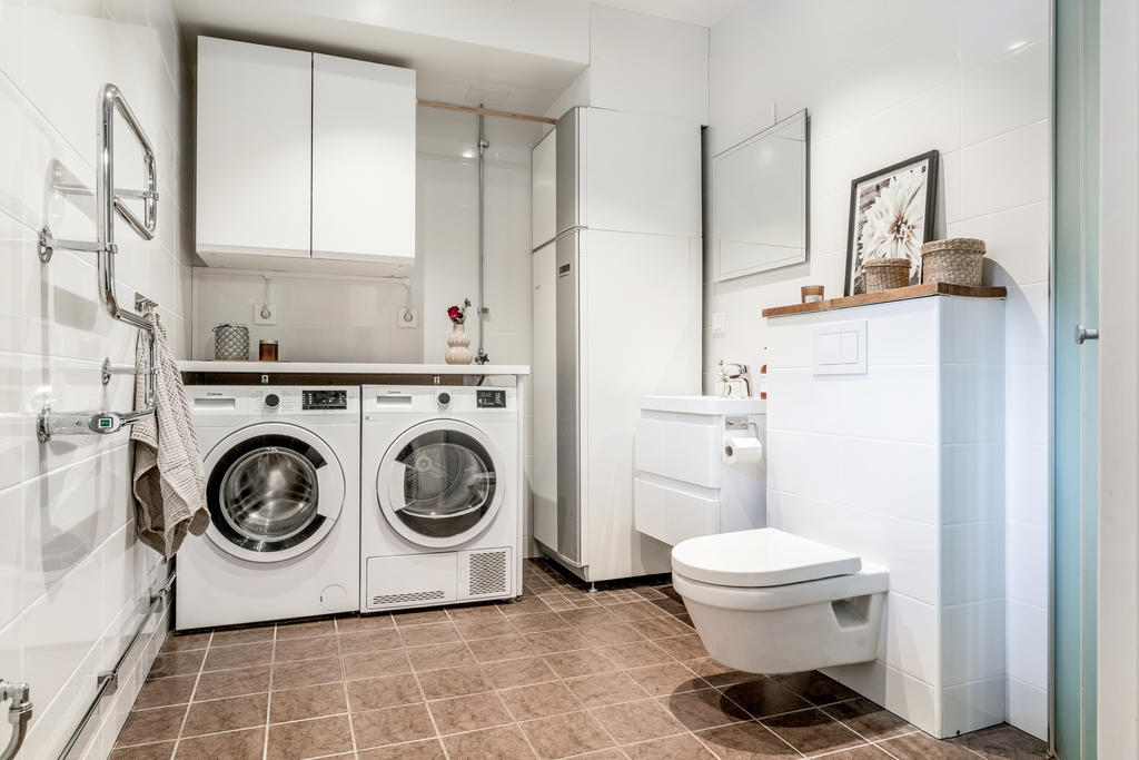 Helkaklat duschrum med tvätt och torktumlare. 