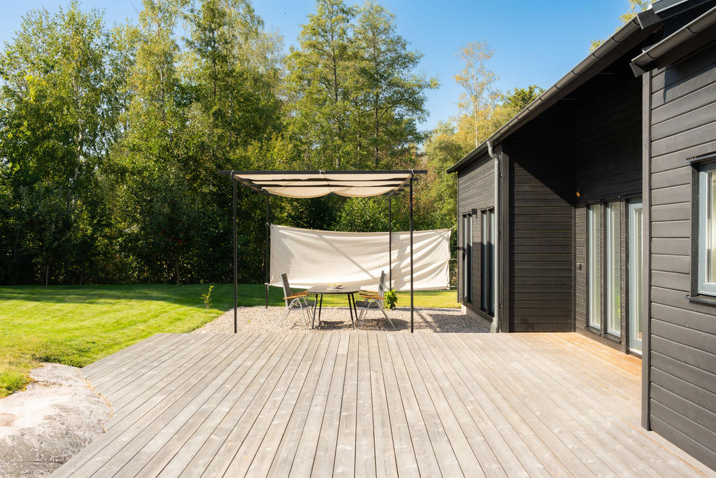 Skyddande träd, stort trädäck och paviljong för varma dagar