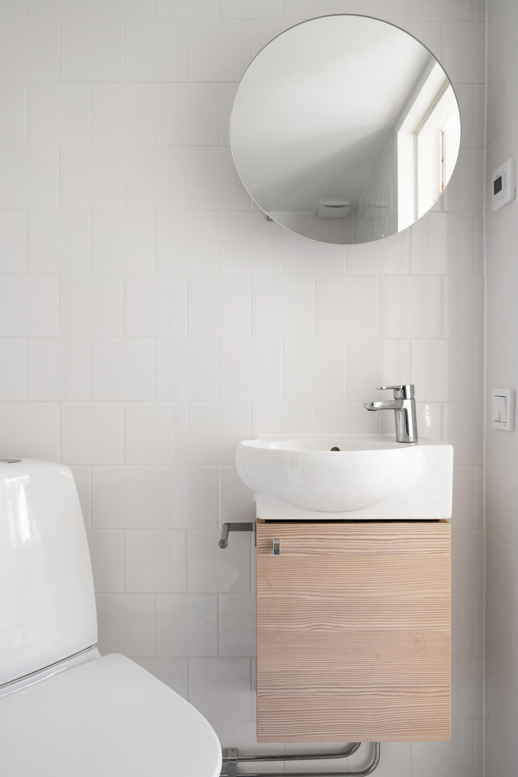 Nygjort helkaklat badrum med stilren design. Dusch, wc, handfat, spegel och kommod finns för din bekvämlighet. Modernt och fräscht för avkoppling och vardagslyx.