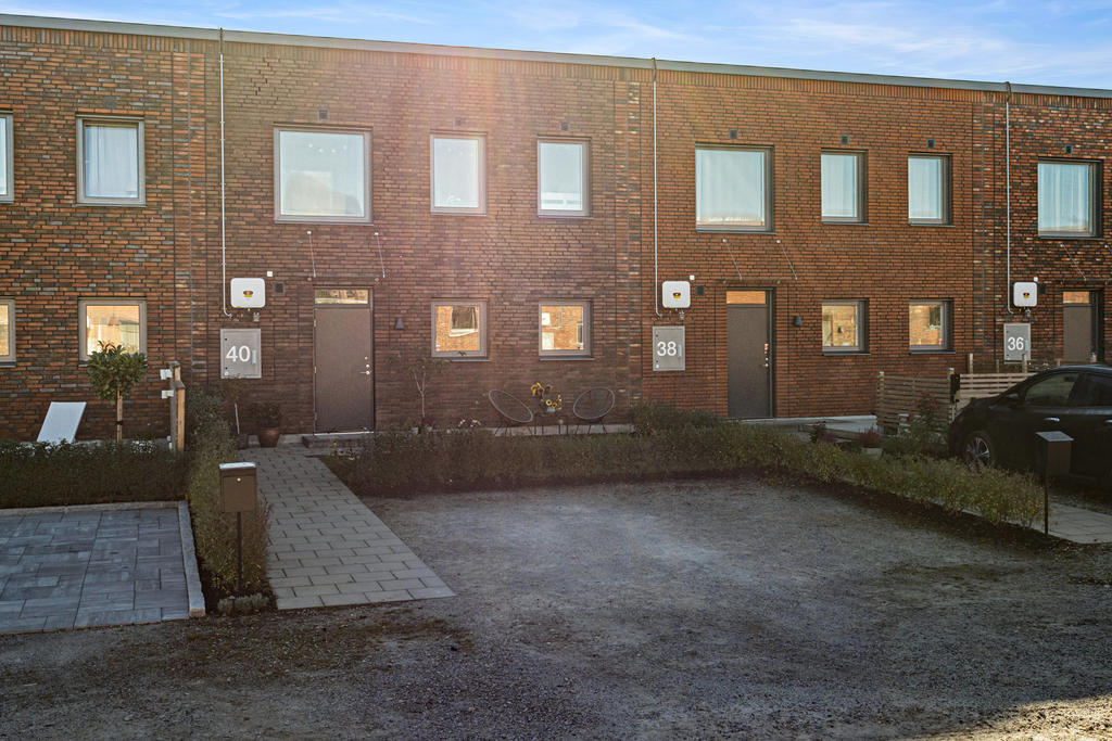 På husets framsida finns ytterligare en uteplats, en liten gräsmatta samt plats för två bilar i bredd på egna tomten