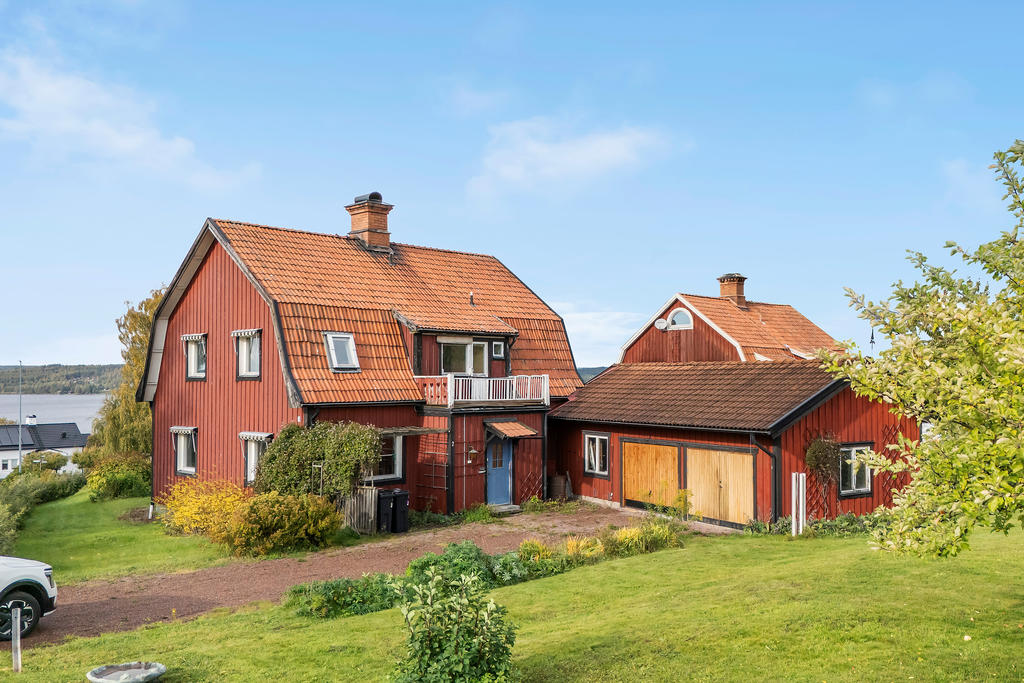 Framsida med garage, kallfarstu och balkong med morgonsol.