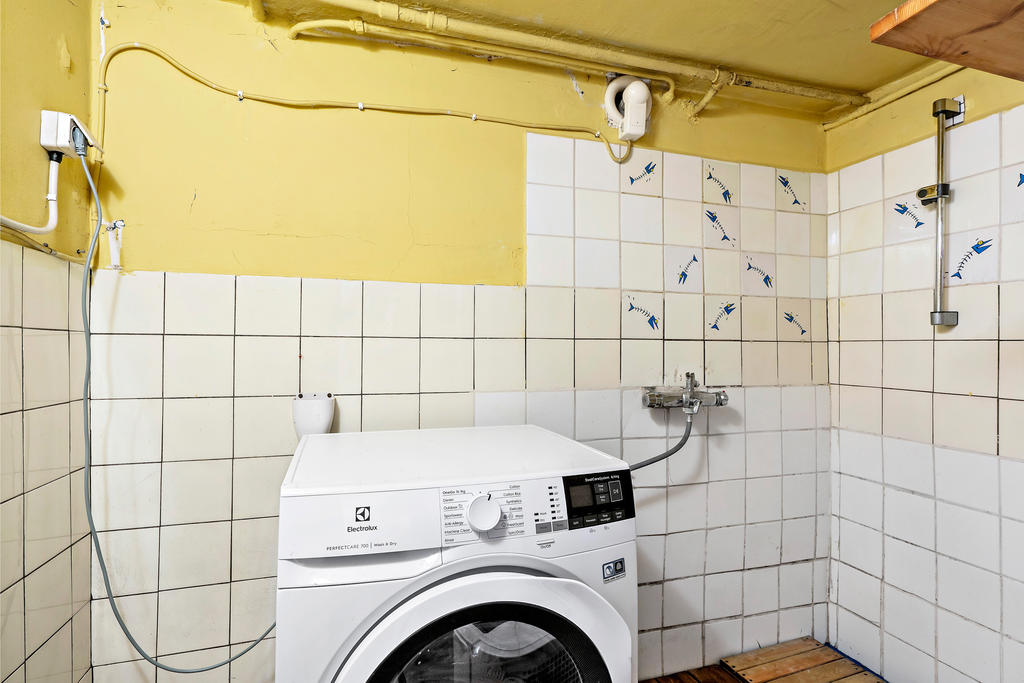 Tvättmaskin med torktumlare och dusch i källaren.