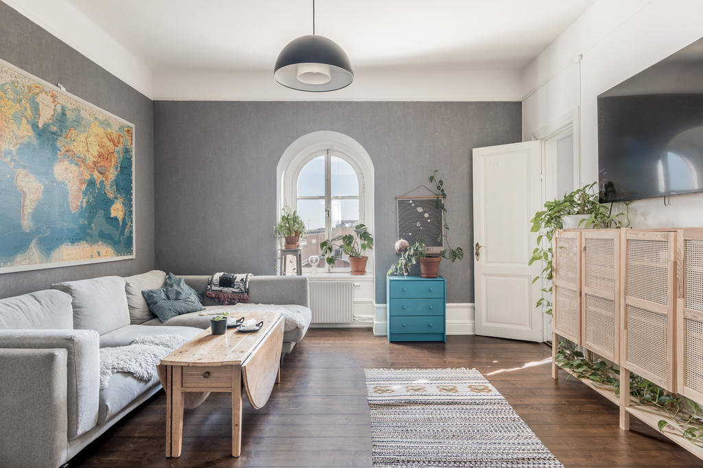 Vardagsrum med högt till tak och vackra trägolv