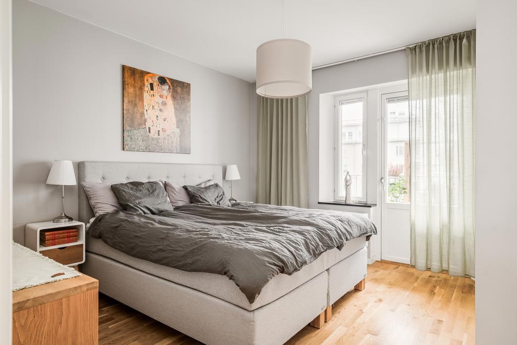 Sovrum med plats för dubbelsäng och utgång till balkong med eftermiddagssol