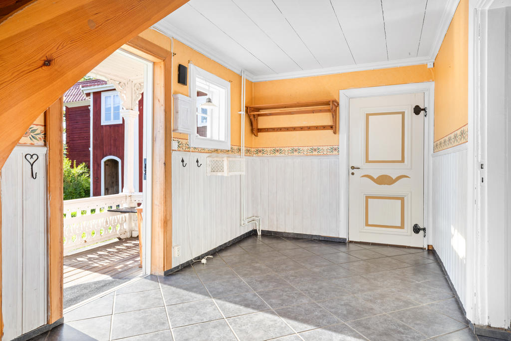 Rymlig hall med klinkergolv och trapp till övervåningen