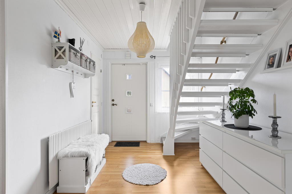 Välkomnande hall med ekparkettgolv och plats för klädavhängning