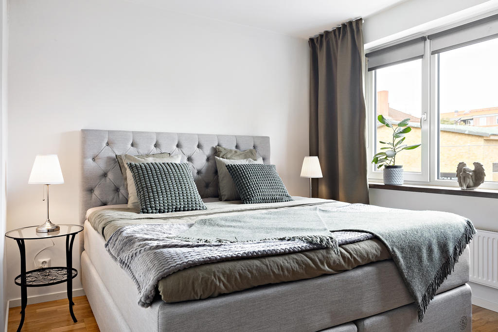 Rymligt sovrum med stora fönster.