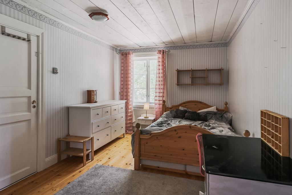 Sovrum med klädkammare och vacker kakelugn med härd av Kinnekullesten. 