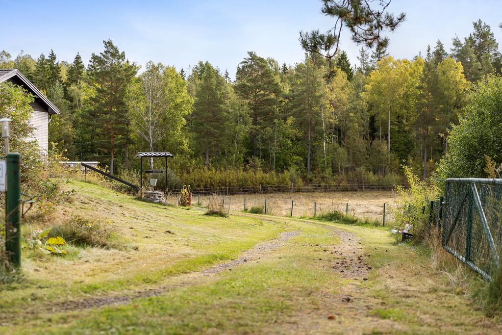 Väg som leder till husets baksida med carport och groventré