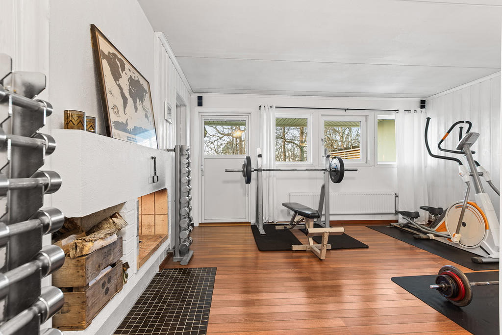 Gillestuga som idag är hemmagym. Utgång till husets baksida trädgård.