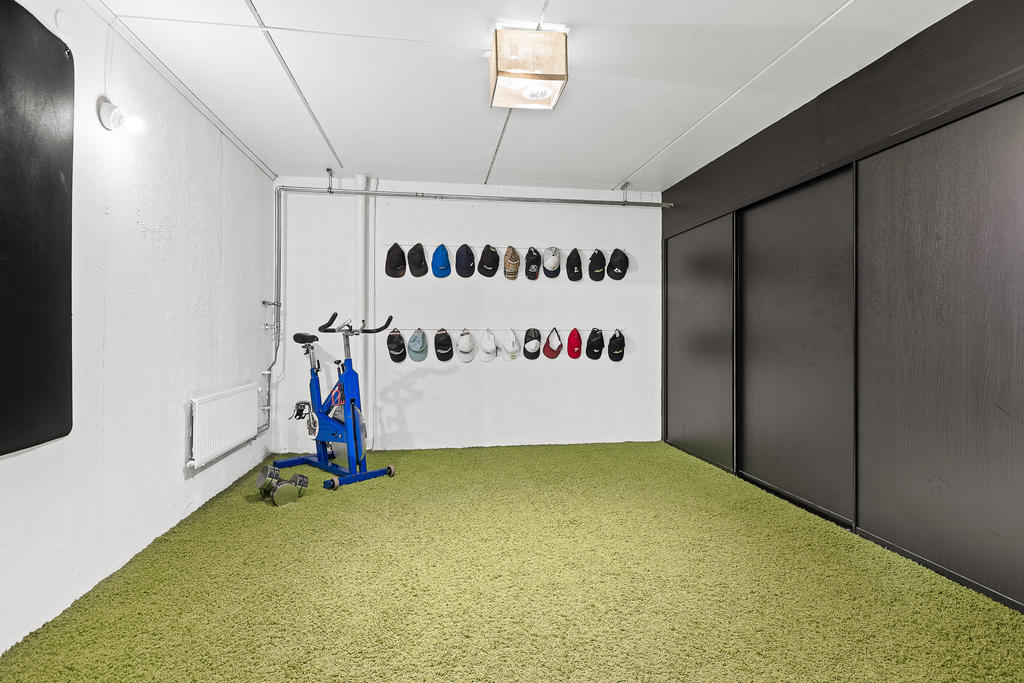 Träningsrum med skjutbara garderobsdörrar som slukar gott om förvaring längs med långsidan