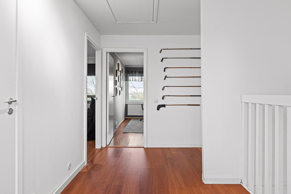 Hallen leder till övre planets tre sovrum, WC & duschrum och förrådsrum