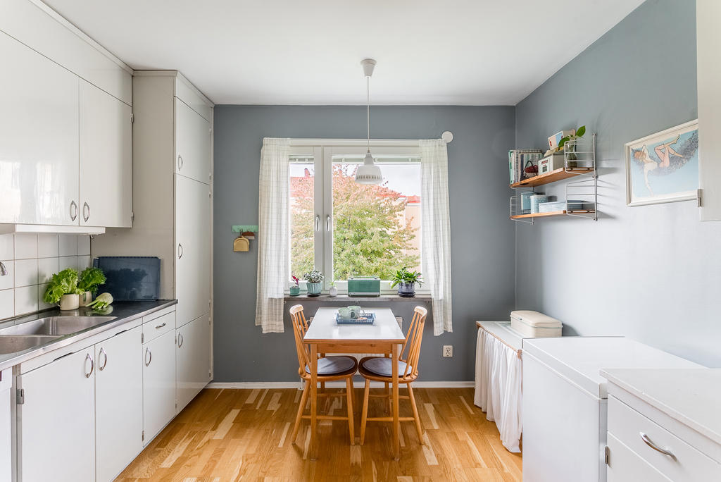 Ljust kök med plats för matgrupp.