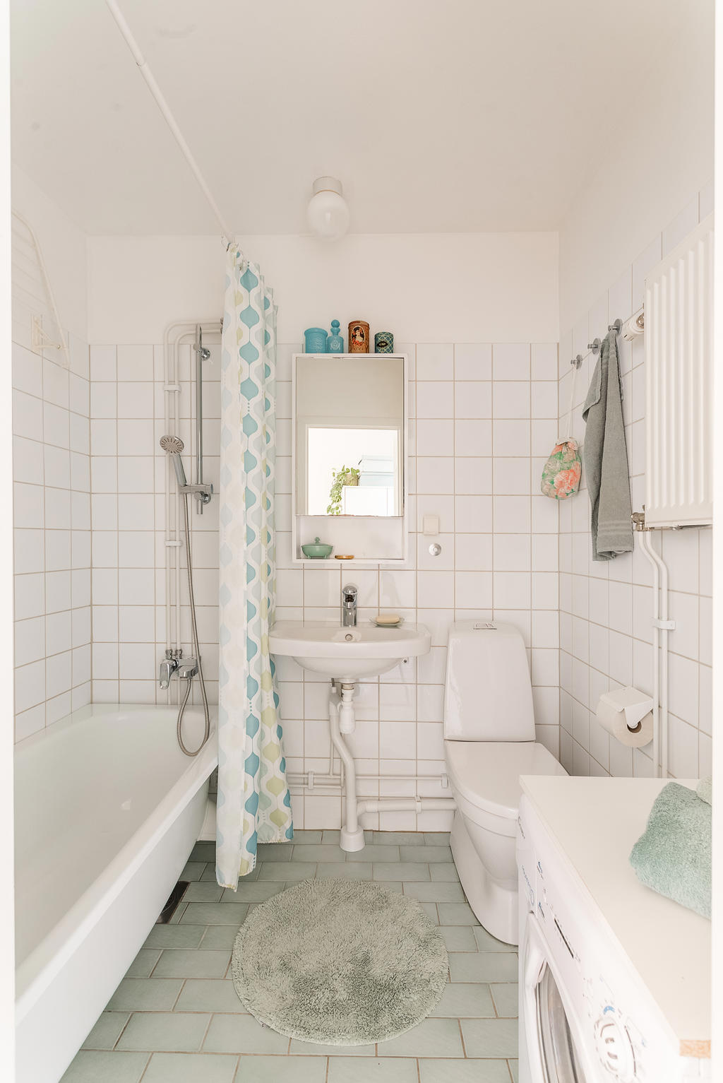 Helkaklat badrum utrustat med tvättmaskin.