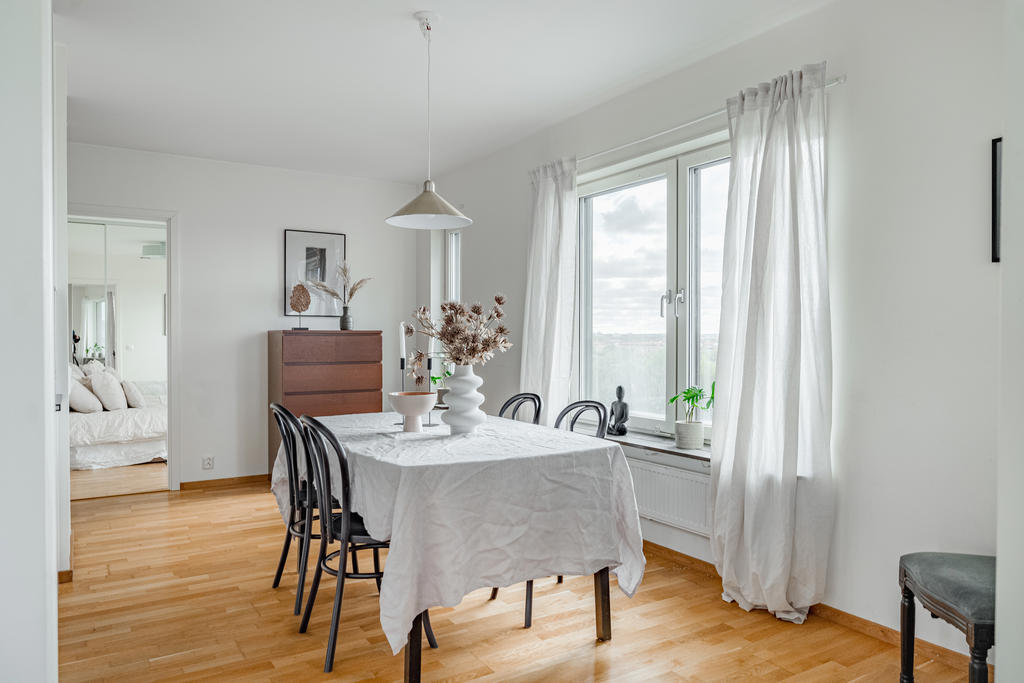 Matrum intill kök med öppen planlösning mot vardagsrum. Fint ljusinsläpp via fönster i två väderstreck.