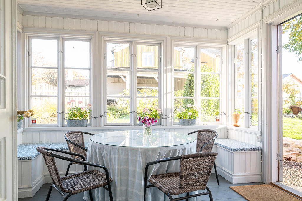 Punchveranda med dubbeldörr till vänster mot gatans entré och till höger mot trädgården