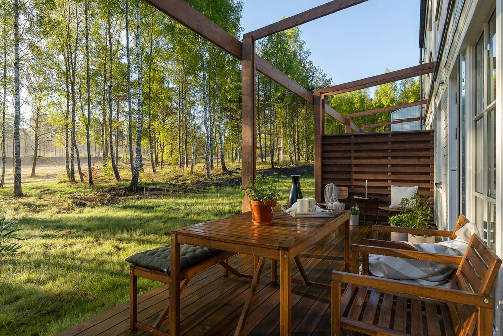 Från vardagsrummet kliver du ut på den större uteplatsen som ligger i anslutning till trädgården på husets baksida. Inspirationsbild från visningshuset på Nässelvägen 6A (127 kvm).