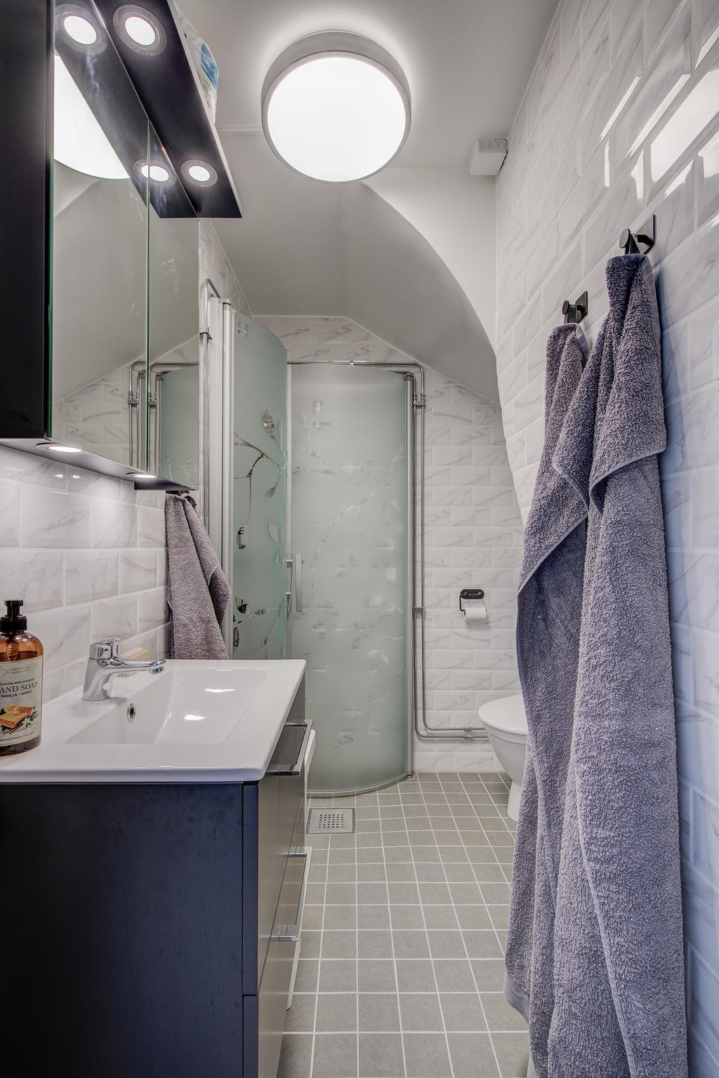 Under trapp finns detta nygjorda badrum från 2023 med klinkergolv och golvvärme (el) samt helkaklade väggar. Duschplats med vikbara duschväggar, tvättmaskin från 2023, toalett och handfat. 